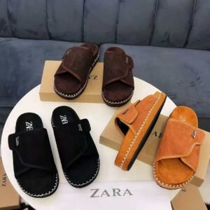A stylish display of Zara suede slide sandals in black, brown, and tan, showcasing the luxurious texture and sleek design.