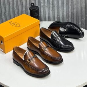 A stylish display of Tods loafers in rich brown and black leather, accompanied by the iconic yellow shoe box, showcasing the brand's commitment to quality and style.