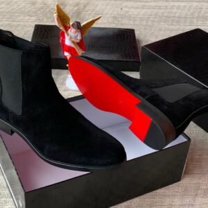 root A pair of luxurious brown suede Chelsea boots with elastic sides, presented in an open black box with a red interior, exuding high-end quality and style.