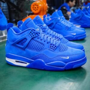 A pair of vibrant blue sneakers with white accents, featuring a sleek design and prominent Nike logo, displayed on a green surface.
