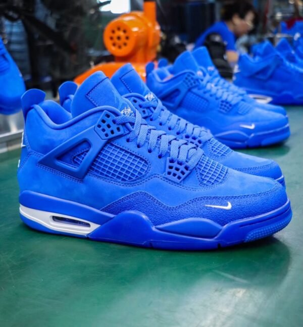 A pair of vibrant blue sneakers with white accents, featuring a sleek design and prominent Nike logo, displayed on a green surface.