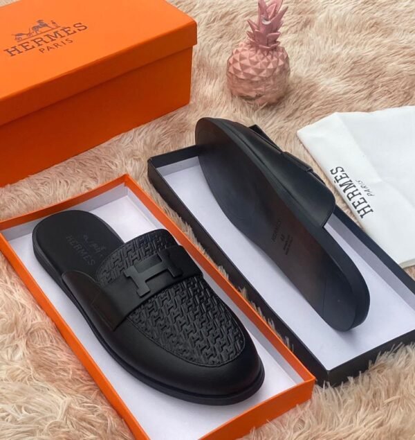 root Luxury black leather Hermes slippers in an orange box on a fluffy surface